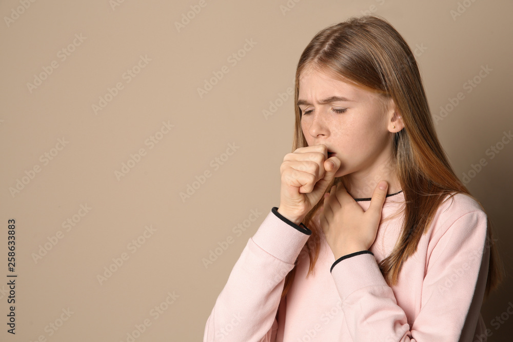 Teenage girl suffering from cough on color background. Space for text Teenage girl suffering from cough on color background. Space for text