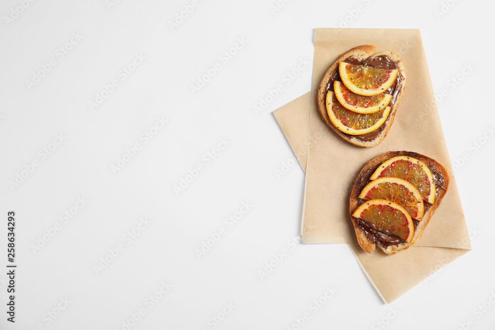 Tasty toasts with chocolate paste, orange and chia seeds on white background, top view. Space for text Tasty toasts with chocolate paste, orange and chia seeds on white background, top view. Space for text
