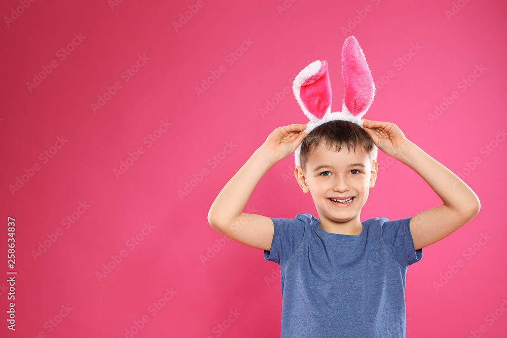 Portrait of little boy in Easter bunny ears headband on color background, space for text Portrait of little boy in Easter bunny ears headband on color background, space for text