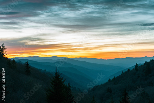 Orange glow from the sun illuminates the sky over the Great Smoky Mountains