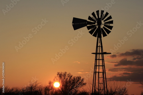 silhouette of windmill at sunset with clouds in Kansas
