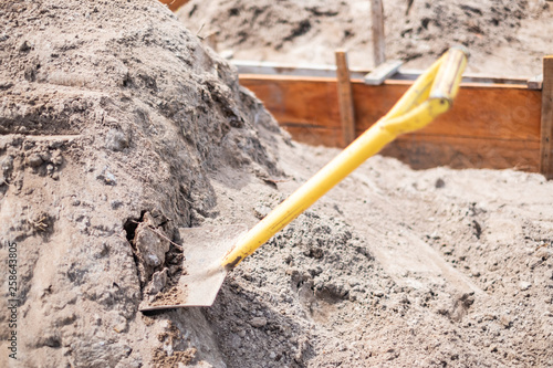 Shovel placed on a pile of sand for construction work. It is used for scooping sand
