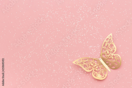 Sparkles glitter and gold tracery butterfly on pink pastel trendy background. Festive background, template