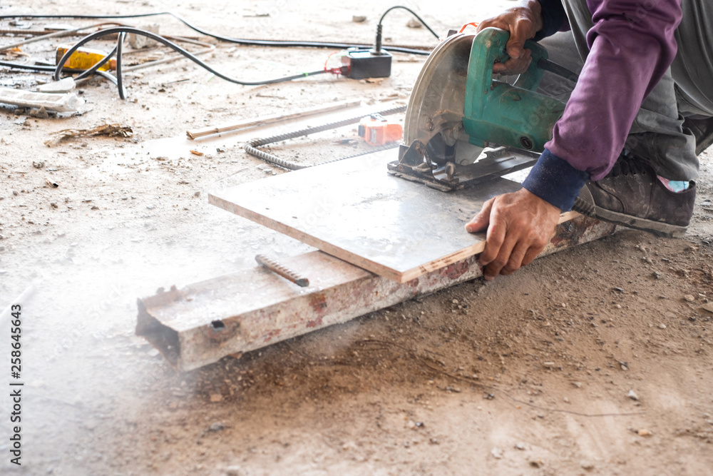 Worker is using wood circular cutter saw cutting wooden board. Worker is using wood circular cutter saw cutting wooden board.