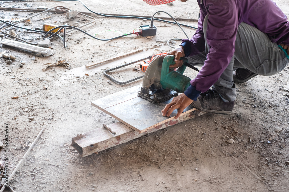 Worker is using wood circular cutter saw cutting wooden board. Worker is using wood circular cutter saw cutting wooden board.