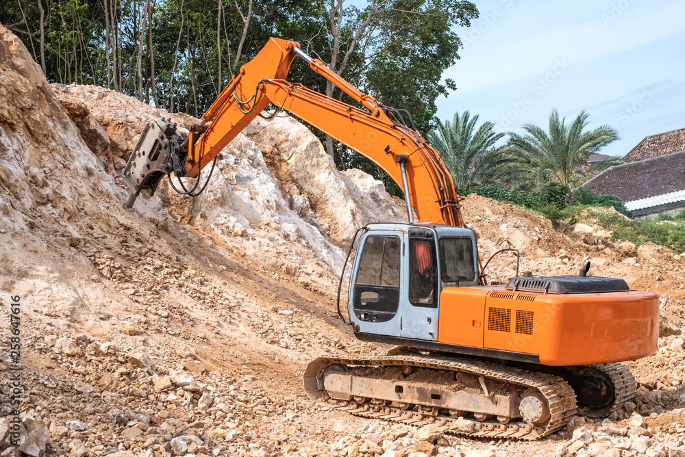 Large hydraulic Jackhammer working on smashing rock. Large hydraulic Jackhammer working on smashing rock.