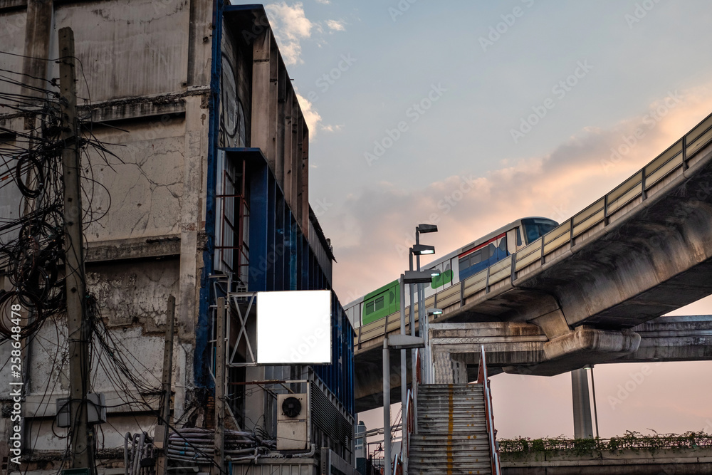 Stairs up to overpass under sky train in Bangkok, Thailand at evening.