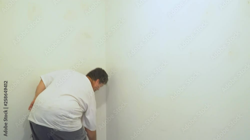 Painter painting wall with white painting a wall with paint roller view of man and young daughter painter in painting Painter painting wall with white painting a wall with paint roller view of man and young daughter painter in painting