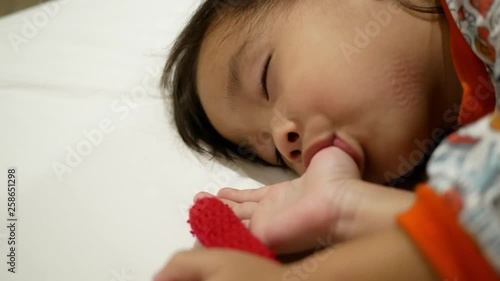 Asian little child are thumb sucking as sleeping in the bedroom. Health care concept.
