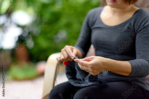 Woman hand knitting in a garden