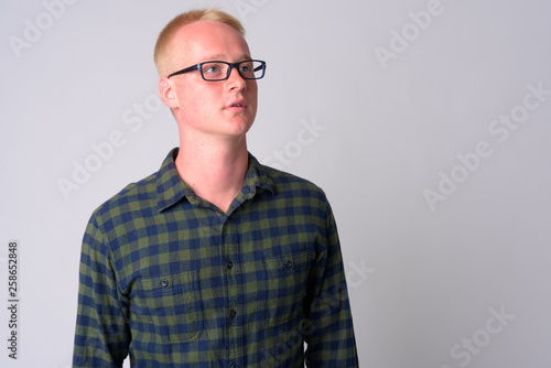 Young blonde hipster man with eyeglasses thinking and looking up © Ranta Images