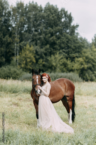 The bride on a horse in the field. Beautiful wedding and photo shoot with a horse. © pavelvozmischev