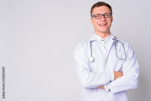 Portrait of happy young man doctor smiling with arms crossed © Ranta Images