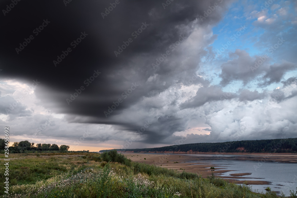 dramatic sky over the river bank in summer