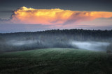 mist swirls through the fields at sunset