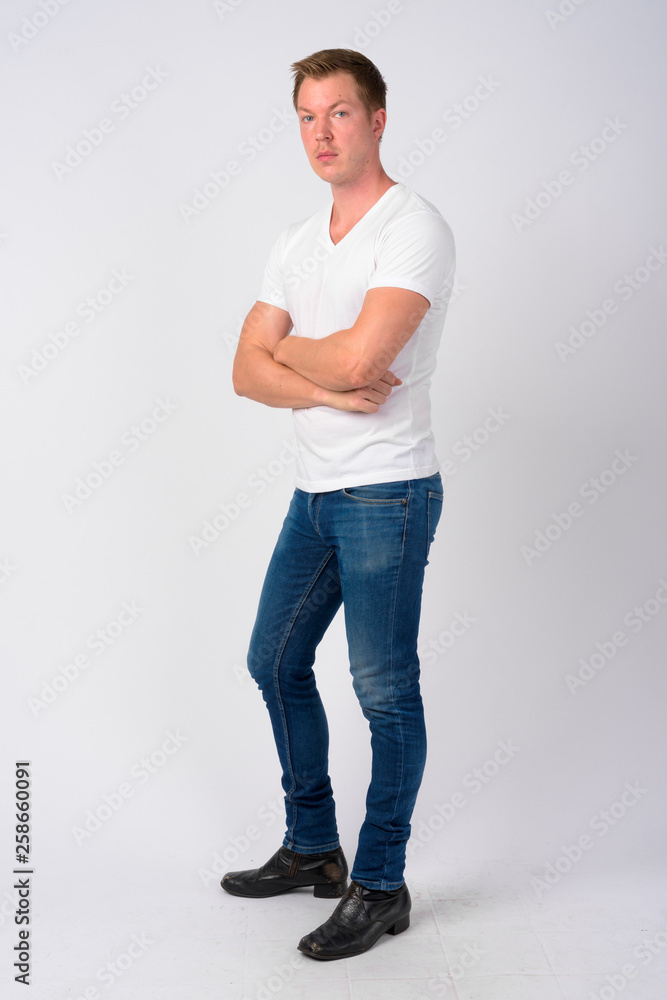 Full body shot profile view of young handsome man with arms crossed Full body shot profile view of young handsome man with arms crossed