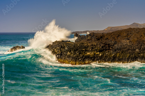 Принти на полотні Spain, Lanzarote, Huge wave breaking into spindrift at lava rocks of los hervide