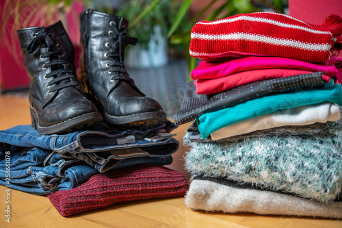 pile of second hand clothing and shoes with computer on floor