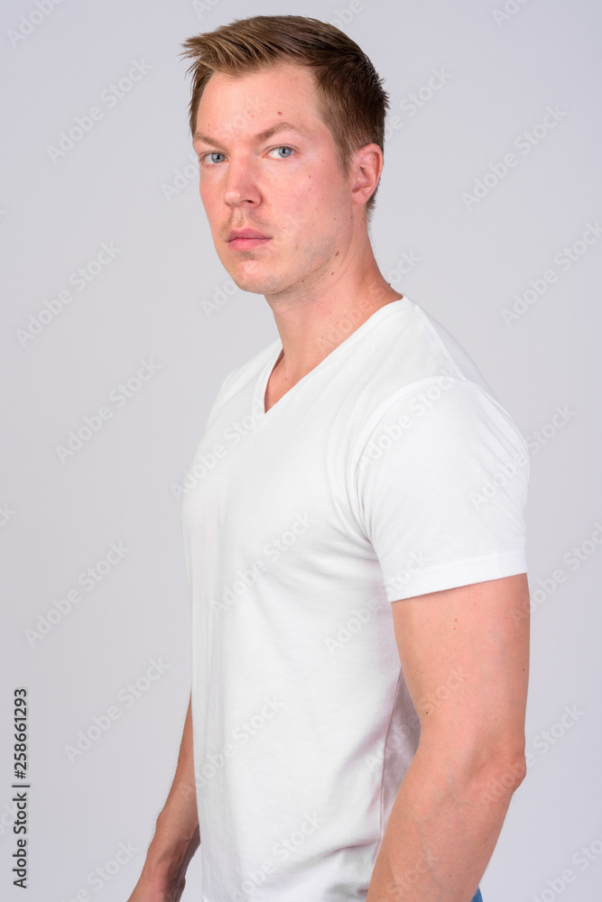Fototapeta premium Profile view of young handsome man looking at camera