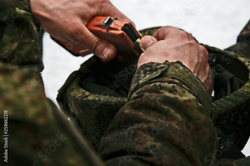 The hands of the military. Man in the winter at work. Strong male hands. bullets. Russian soldier.
