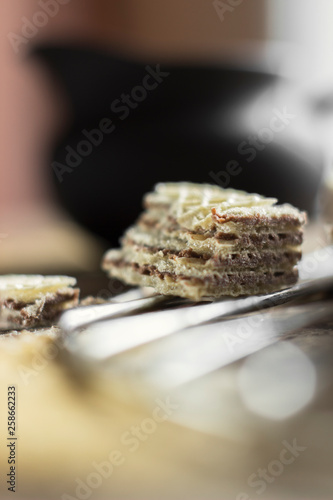 Sweet russian artek waffles on wooden background, with a pot of milk. Traditional sweets and dessert.