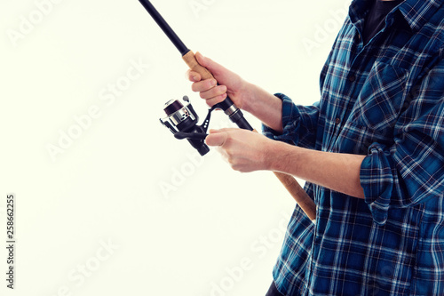 man with fishing rod and blue plaid shirt