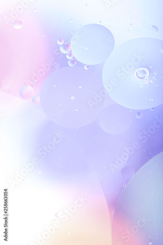 Blurred abstract background. Image of pink, blue, gray and yellow circles of different sizes. Cropped shot, vertical, abstract, blurred, free space, nobody.