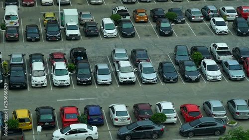 time lapse pan shot of an outdoor parking lot or Park-and-Ride area with lots of people and vehicles coming and leaving, day time sunny weather conditions