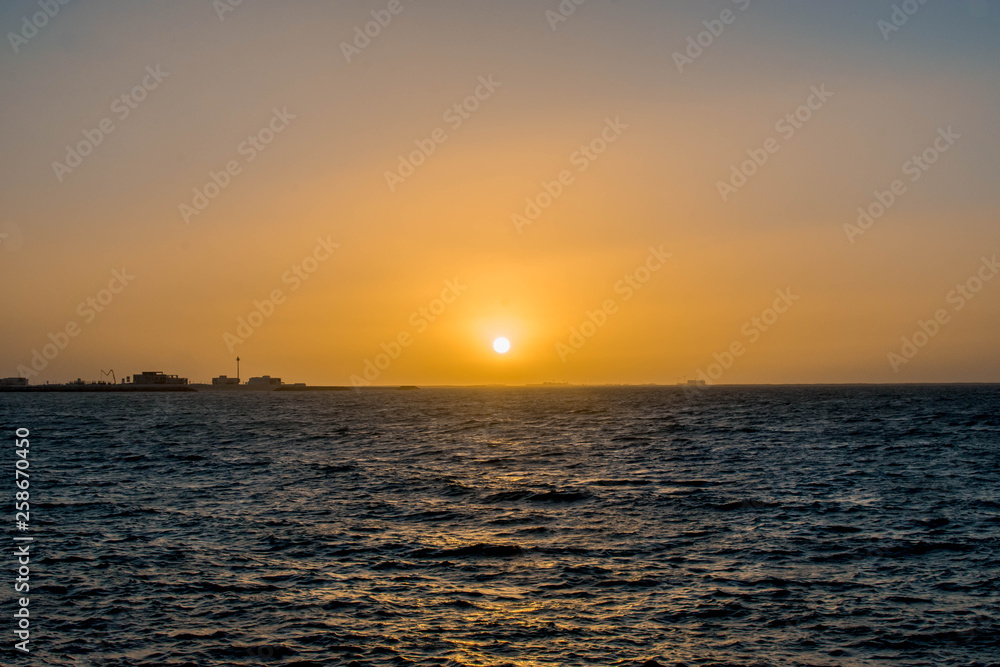 Beautiful Sun View at Beach with orange sky and yellow light reflection on sea water waves