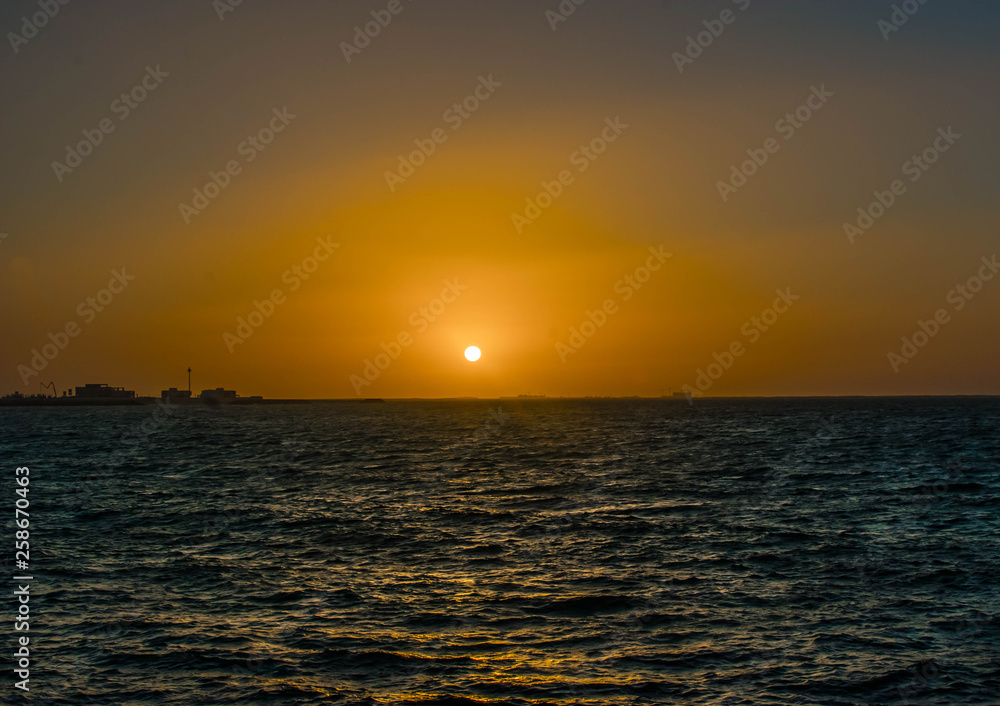 Beautiful Sun View at Beach with orange sky and yellow light reflection on sea water waves