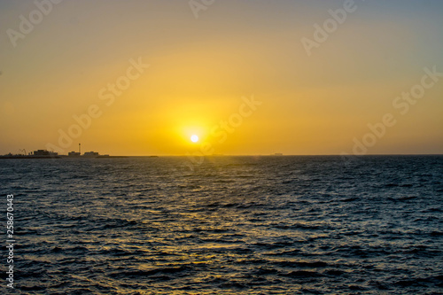 Beautiful Sun View at Beach with orange sky and yellow light reflection on sea water waves