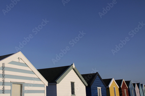 Colorful English beach huts against a blue sky