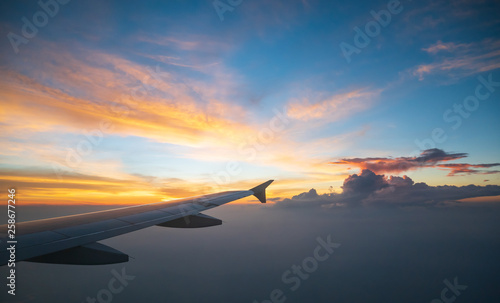 View from the Airplane window seat. Twilight view in the sunset tiem reduces speed and landing. Reduce the level of flight to destination with clouds and colorful sky background photo