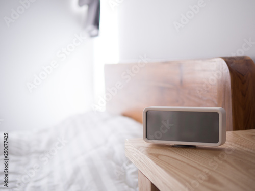 blank displays on digital alarm clock's screen on wood table.
