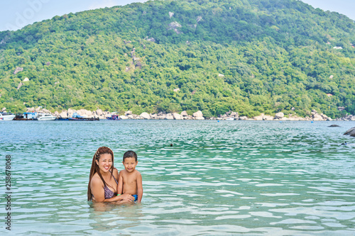 Mom and son Asians bathe in the sea