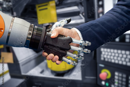 Hand of a businessman shaking hands with a Android robot.