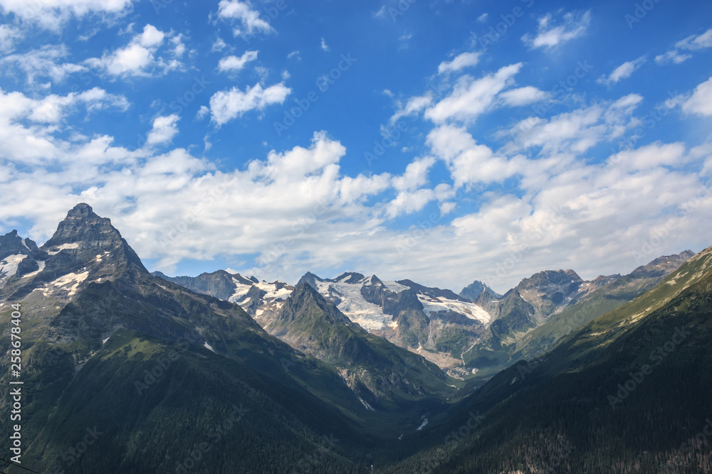 Panorama of mountains scene with dramatic blue sky in national park of Dombay