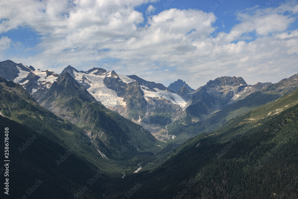 Panorama of mountains scene with dramatic blue sky in national park of Dombay