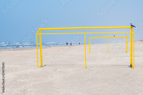 Yellow football goal on the beach.