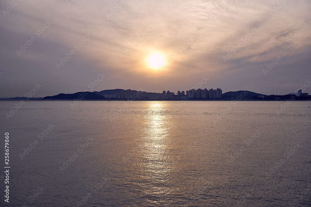 The sunset view of apartments across the ocean at Incheon, South Korea.