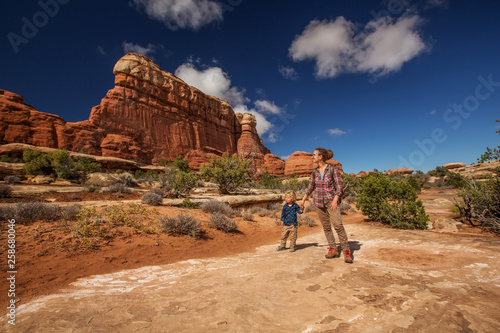 Hiker with boy in Canyonlands National park, needles in the sky, in Utah, USA