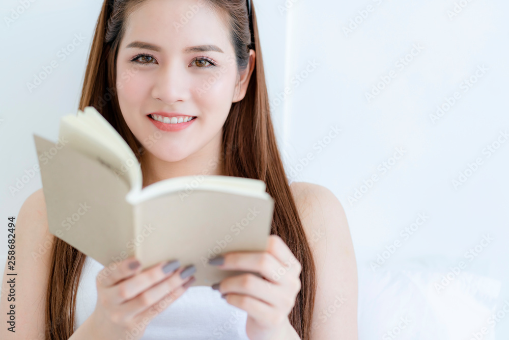 beautiful attractive asian woman enjoy reading book on bed portrait of asian long hair woman enjoy weekend activity white bedroom beautiful attractive asian woman enjoy reading book on bed portrait of asian long hair woman enjoy weekend activity white bedroom
