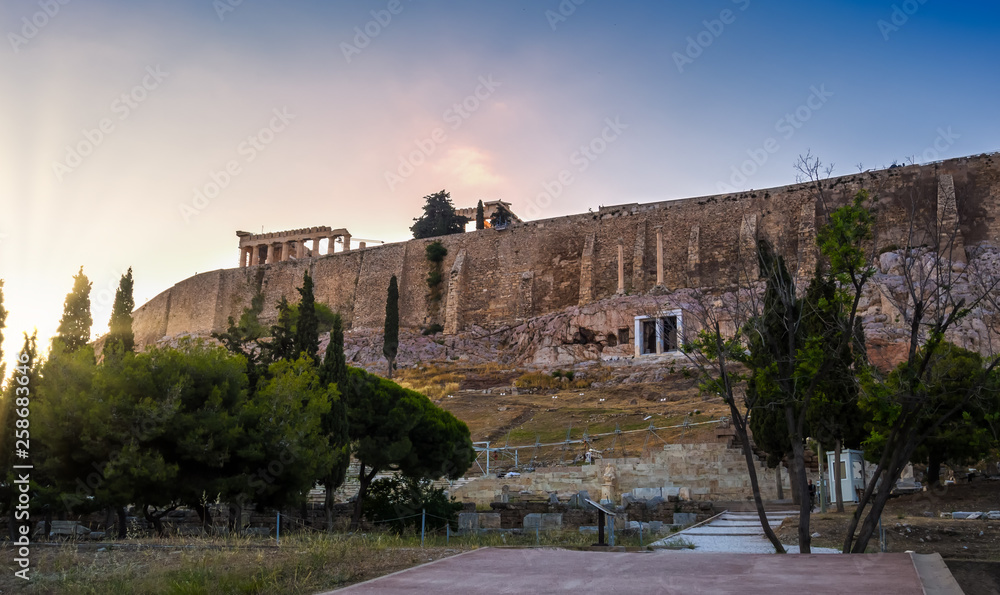 View of Acropolis walls and the hill slopes and theater of Dionysus in Athens, Greece at sunset