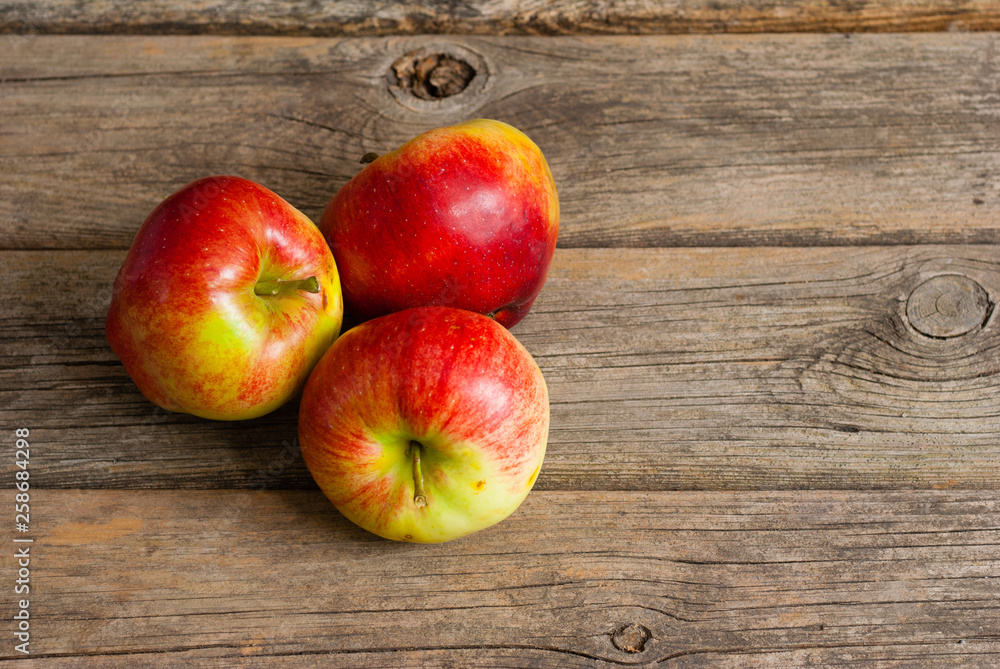 three apples on old wooden background three apples on old wooden background