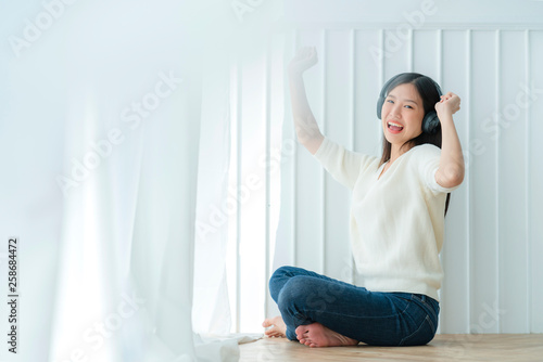 attractive asian beautiful woman enjoy music from headphone with happiness and joyful,portrait of asian white dress woman