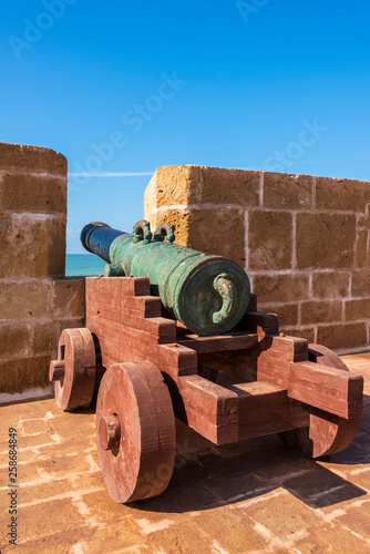 View on Fort with old Historical portugese Metal Cannons In a Fortress. Walls with cannons and tower of the old fort in the port and coast of the historic city of Mogador © dsaprin