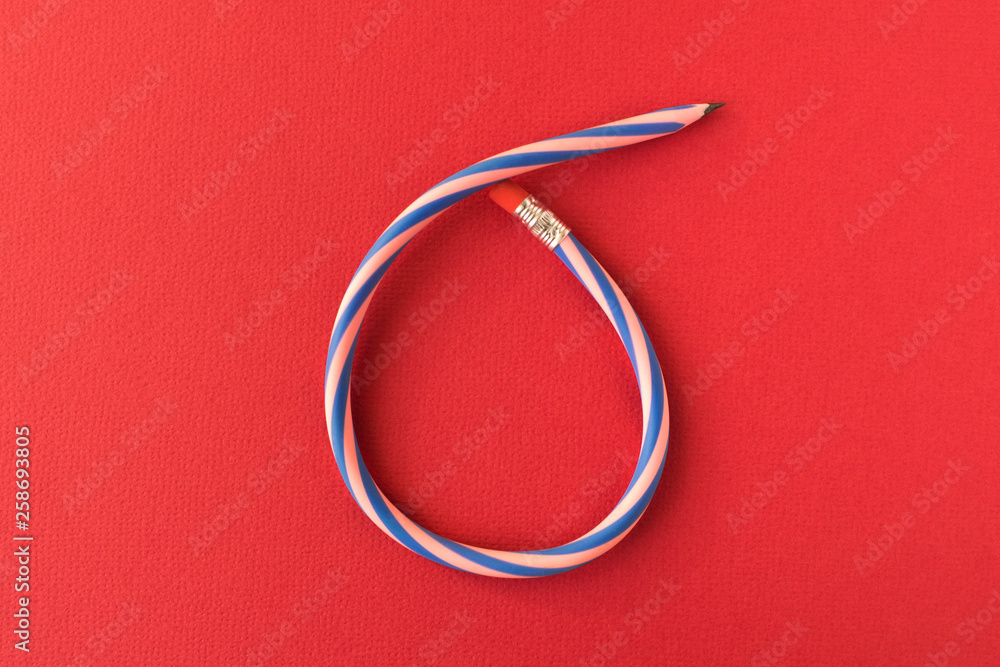 Fototapeta premium Flexible pencil . Isolated on red background. Bending pencil.