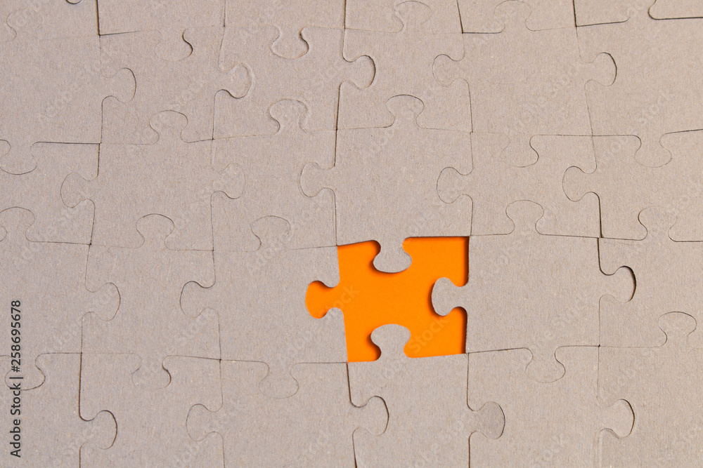 Fototapeta premium Jigsaw puzzles on orange background. The concept of development of thinking.