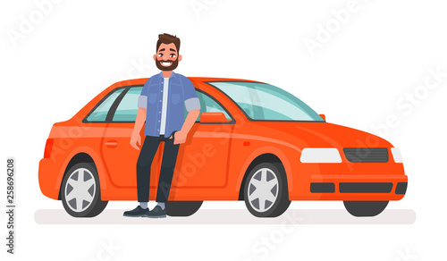 Happy successful man is standing next to a red car on a white background