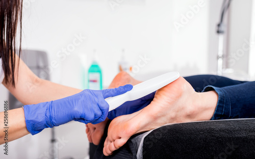 Peeling feet pedicure procedure at cosmetic salon